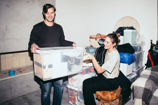 Happy couple helping each other during relocation of house