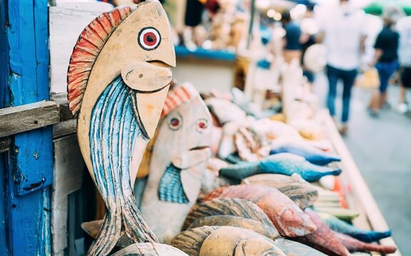Handmade colored wooden toy in the form of fish for sale at street souvenir market