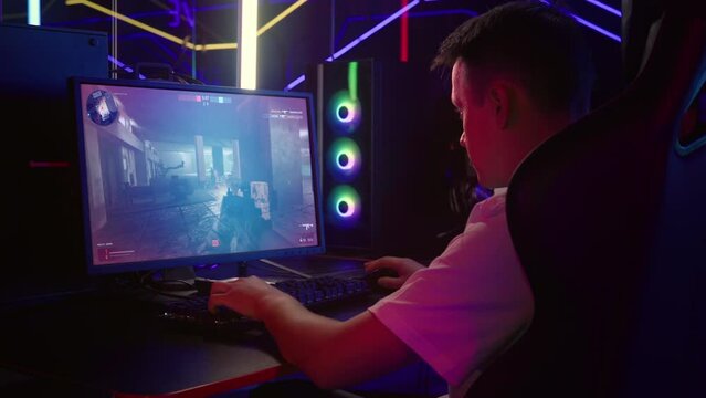 Gamer Combats Enemy Team To Achieve Victory In Internet Shooter E-Sports Tournament. Gamer Plays As Soldier In Military Shooter Internet Multiplayer. Gamer Defuses Bomb Winning Internet Shooter Match