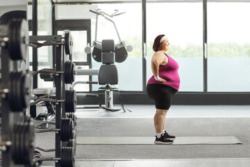 Corpulent woman standing at a gym