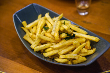Fried potatoes with salt and seaweed on a wooden table