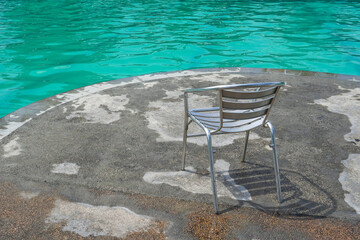 the swimming pool is clean and the rest chairs are empty
