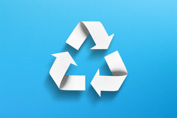 Recycle symbol made of paper on blue background