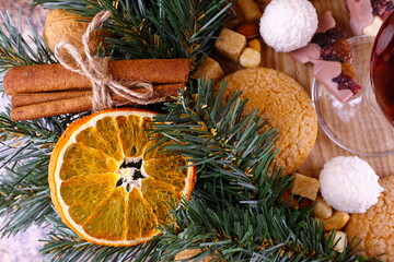 Festive composition on the theme of Christmas with wreath of coniferous branches and orange slices and sweets.