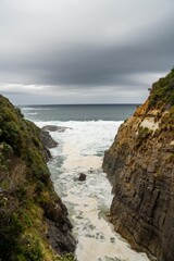 waves breaking on rocks in on the coast by the sea in tasmania australia in summer