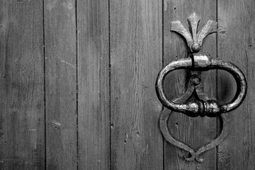 Old metal door handle in black and white.