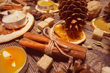 Festive composition of natural cones, nuts, dried orange slices, spices and tea candles on the theme of Thanksgiving and Christmas