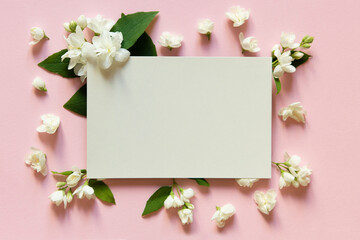 Blank greeting card, invitation and envelope mockup. Minimal floral frame made of jasmine flower. Flat lay, top view. Happy mother's day, women's day or birthday, wedding composition.