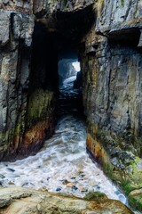 australia sea cave with waves crashing through it in tasmania