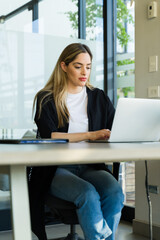 Portrait of a cute Caucasian office worker using a laptop computer in an office