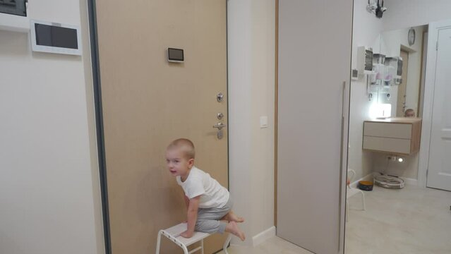 child little boy looking through intercom screen of door peephole surveillance camera on entrance door. Home security and video surveillance. Device to see the person behind the door.