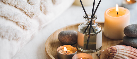 Cozy corner for home meditation and relaxation. Aroma diffuser, burning candles, stones for comfort, pleasure, aromatherapy. Decor for apartment, house, indoors design. Banner