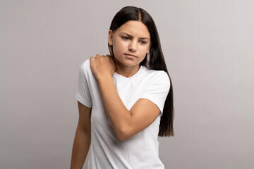 Upset teen girl feel discomfort ache pain after long computer study in incorrect posture. Teenager...