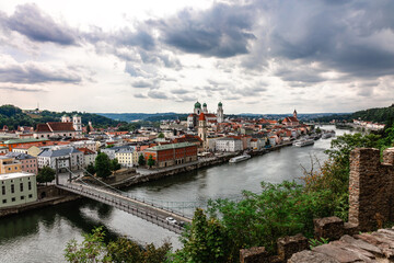 Obraz premium Panoramic view of Passau. Top view of suspension bridge. Aerial skyline of old town with beautiful reflection in Danube river, Bavaria, Germany. High quality photo