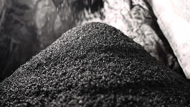 Biochar crumbles in a heap, coal particles falling, Pyrolysis, Decarbonization.