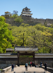 Marugame, Kagawa prefecture - April 14, 2018: Main entrance gate of Marugame castle with castle tower in the background