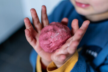 Child having fun modeling salt dough, authentic activity with natural pink coloring beet juice,...