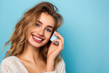 Fototapeta premium smiling beautiful girl holding a bank card, shopping concept, on a blue background