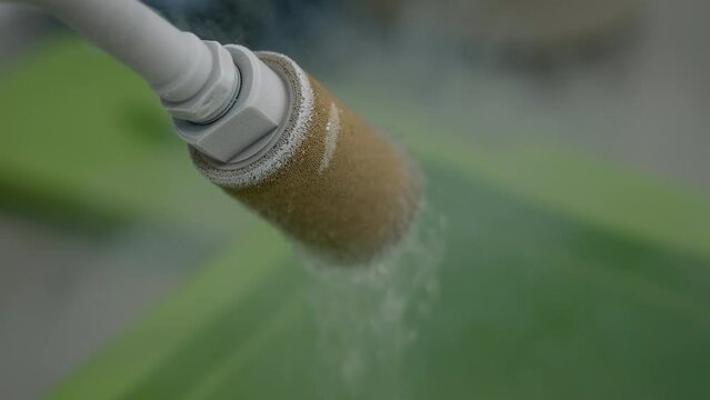 Close-up of a tube spraying the freezing liquid nitrogen into the green box. Tube the human egg with freezing liquid. Tube covered with frost freezing the samples using cold liquid.
