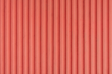 light red, dark peach old concrete background wall with vertical line ribbed that are soundproof. Stripes as a texture.