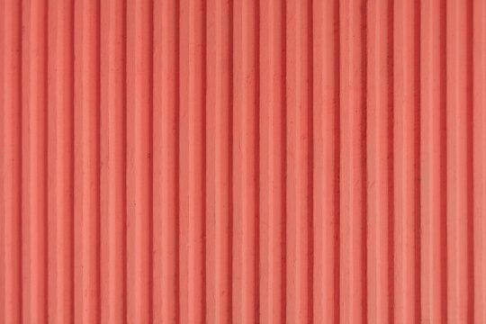 light red, dark peach old concrete background wall with vertical line ribbed that are soundproof. Stripes as a texture.