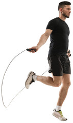 Full-length image of muscular man training, doing exercises with jumping rope isolated on...
