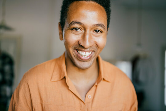 Portrait of smiling man with nose ring at home