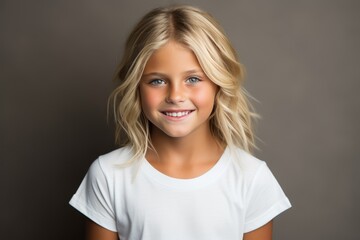 Smiling teen girl presenting blank white t-shirt for advertising campaign in studio setting
