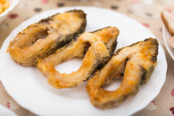 Pieces of the middle part of the carp baked on a white plate