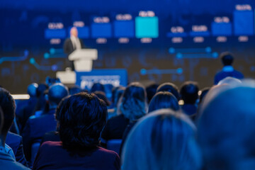 Audience attentively listening to a keynote speaker at a professional event or business conference.