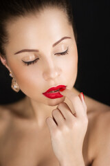 Fototapeta premium Close-up portrait of a beautiful girl on a dark background