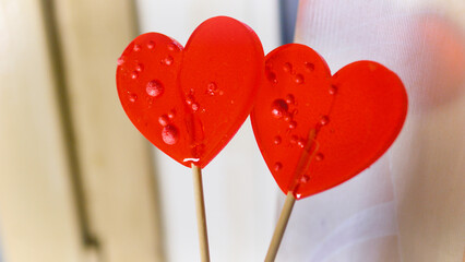 Valentine's Day concept. Two red paired heart-shaped lollipops.
