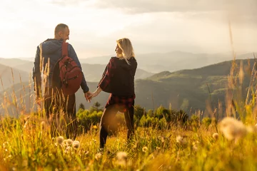 Tuinposter travel to mountains, tourists hikers with backpacks at sunset enjoying panoramic view © Angelov