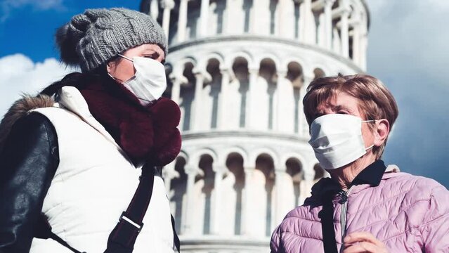 Two women wearing health mask visiting Field of Miracles, Pisa