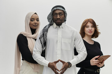 Arabic businessman stands confidently alongside two businesswomen, portraying a poised and diverse...
