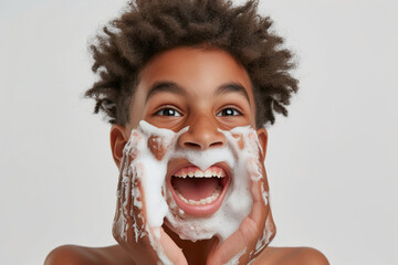 Handsome nervous African American teenage boy with foam on face learning to shave isolated on white studio background
