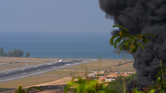 Aircraft landing at Phuket Airport. Airport fire department training. Black smoke at the airport, fire