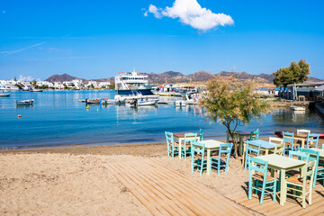 Greek tavern restaurant with tables on beach in Pollomia port, Milos island, Cyclades, Greece - obrazy, fototapety, plakaty
