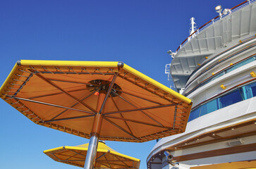 Deck chairs or sun loungers on balcony or terrace or patio pool deck of luxury modern cruise ship...