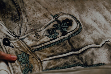 Old Bavarian shorts on a shelf in a sewing workshop.The tailor points to an old pattern.