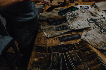 Making and sewing traditional Bavarian shorts. Lederhosen lie on the tailor's table.