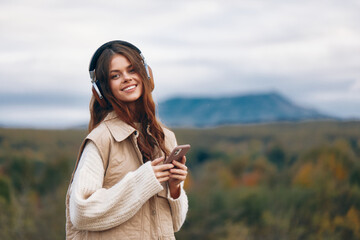 Mountain Woman: A Smiling Tech-savvy Tourist's Selfie Adventure.