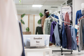 Donation box filled with used clothing for charity in shopping mall boutique. Container with second...