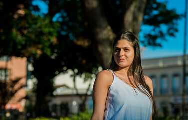 mujer joven mirando a la camara mientras esta en un parque al aire libre 