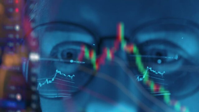 Trader wearing glasses is working on laptop computer. Screen with stock market charts and Bitcoin BTC or Ethereum ETH data analysis reflection. Broker trading online. Altcoins crypto currency trading