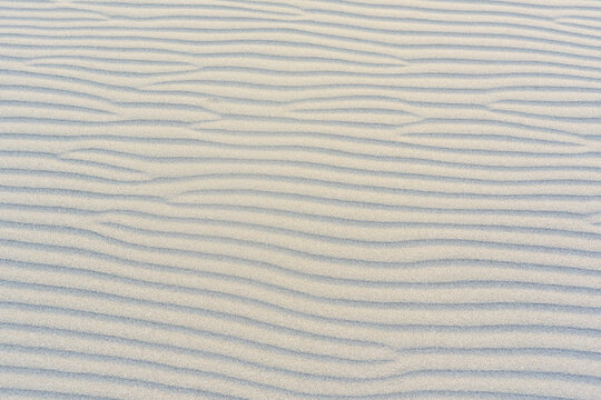The beach with black sand. Background, texture, wavy pattern of the sand of the Adriatic Sea on Velika Plaza beach in Ulcinj, Montenegro.