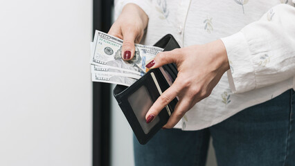 Woman's hands taking out money from wallet, dollar banknote cash - obrazy, fototapety, plakaty