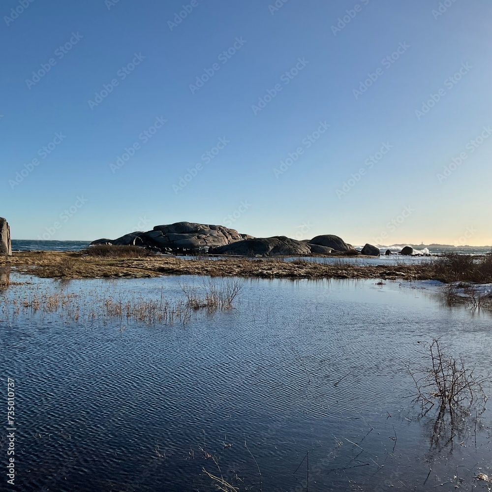 Sticker Serene body of water with distant rocks