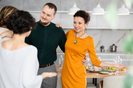 Married Couple Welcoming Guests For Diner Party At Home