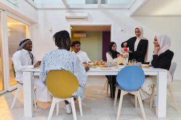 In the sacred month of Ramadan, a Muslim family joyously comes together around a table, eagerly awaiting the communal iftar, engaging in the preparation of a shared meal, and uniting in anticipation